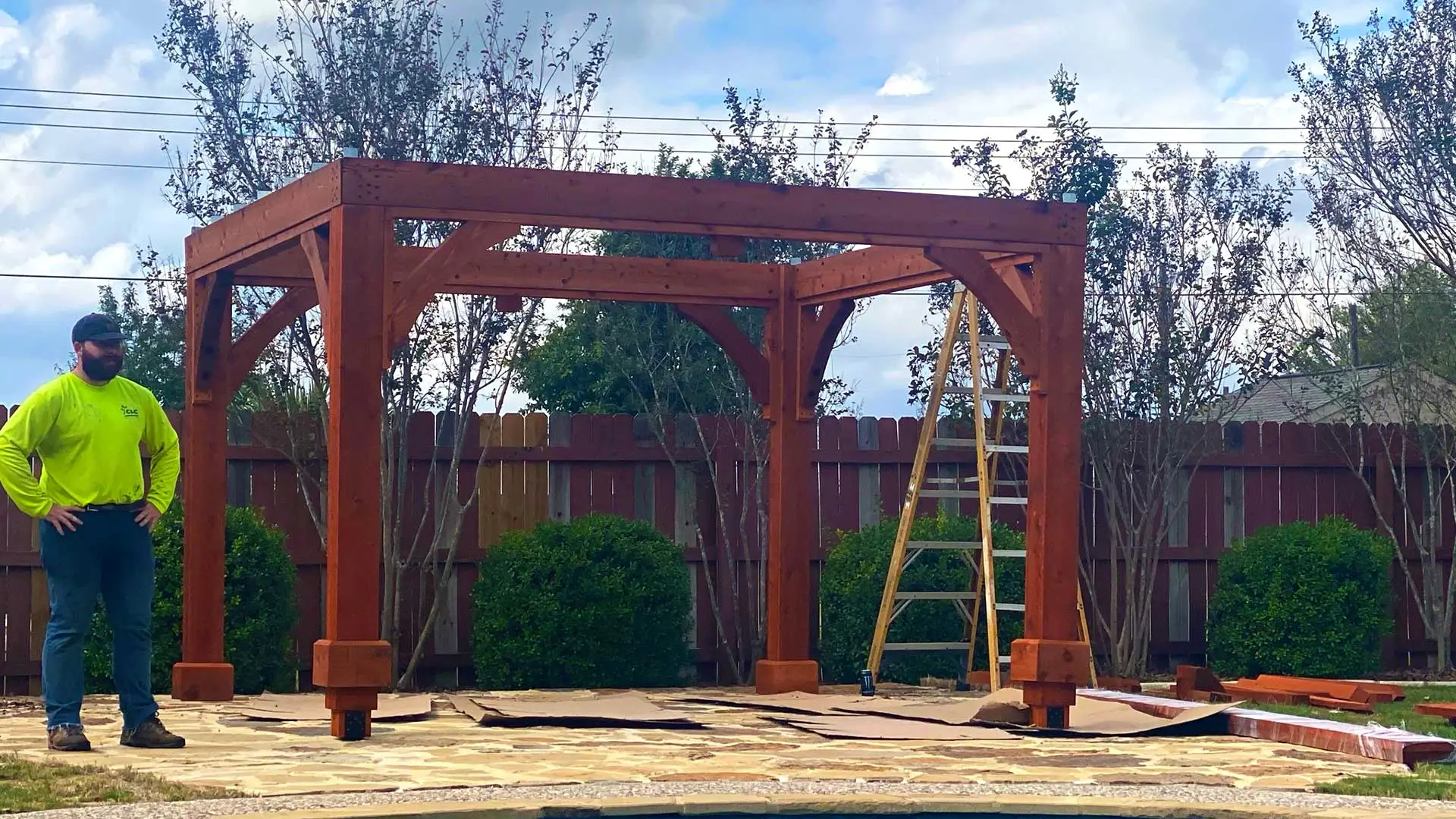 CLC Landscaping crew leader overseeing a pergola installation in Kyle, TX.