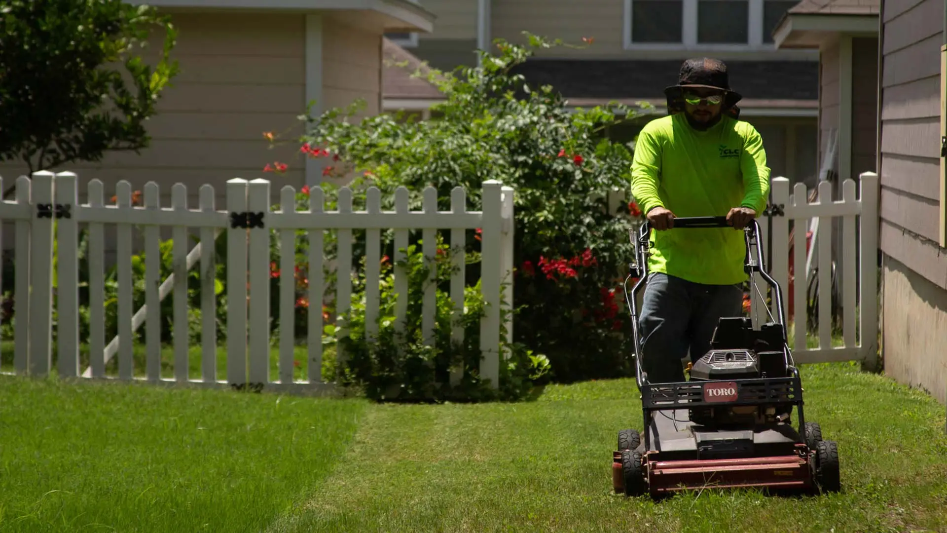 CLC Landscaping lawn care worker mowing a yard in New Braunfels, Texas.