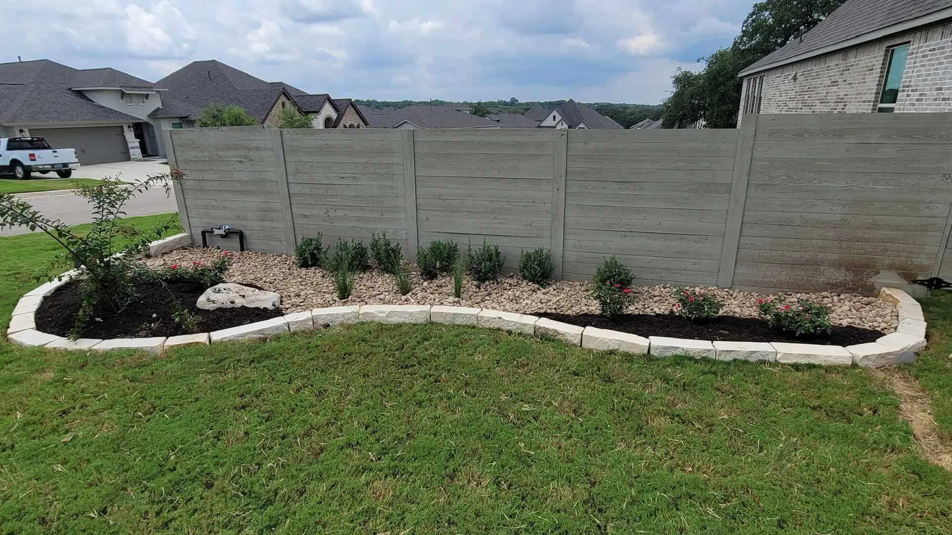 Custom landscape beds along a fence at a home near New Braunfels, TX.
