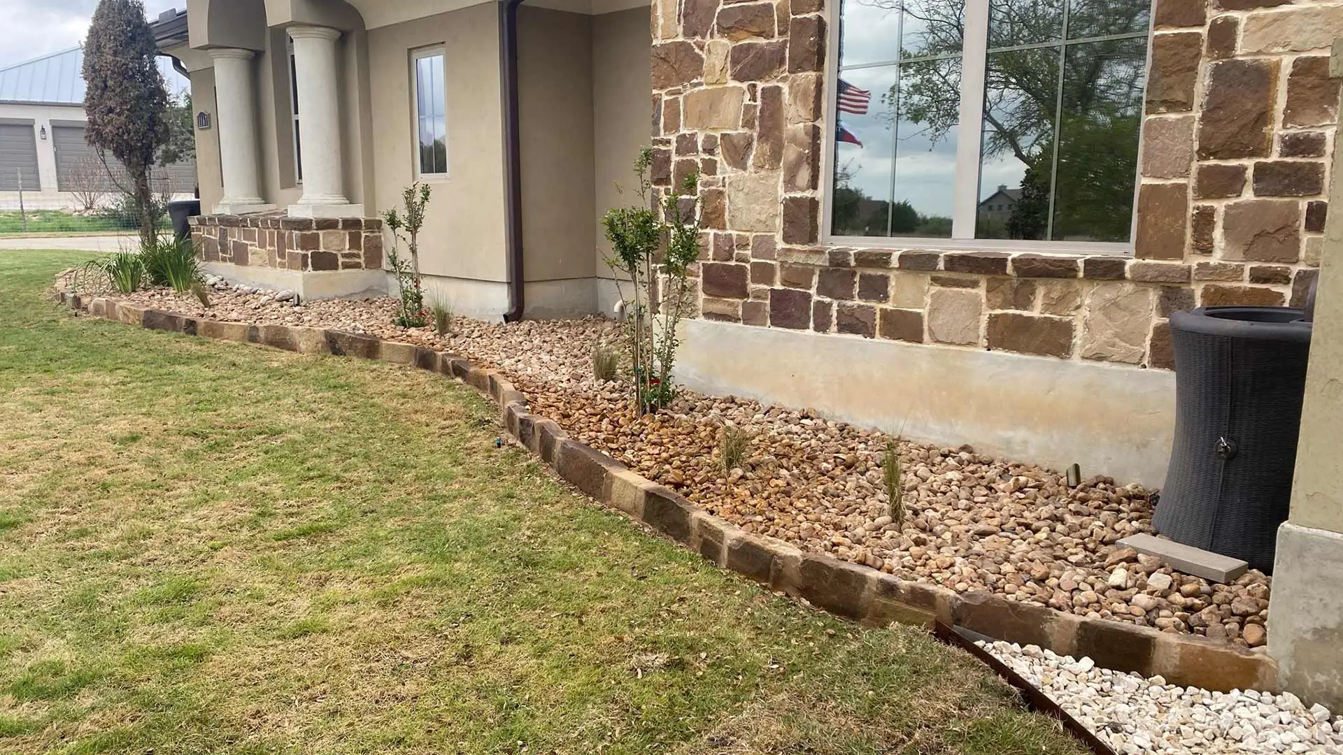 Natural stone landscape bed with mulch around a home in San Marcos, TX.