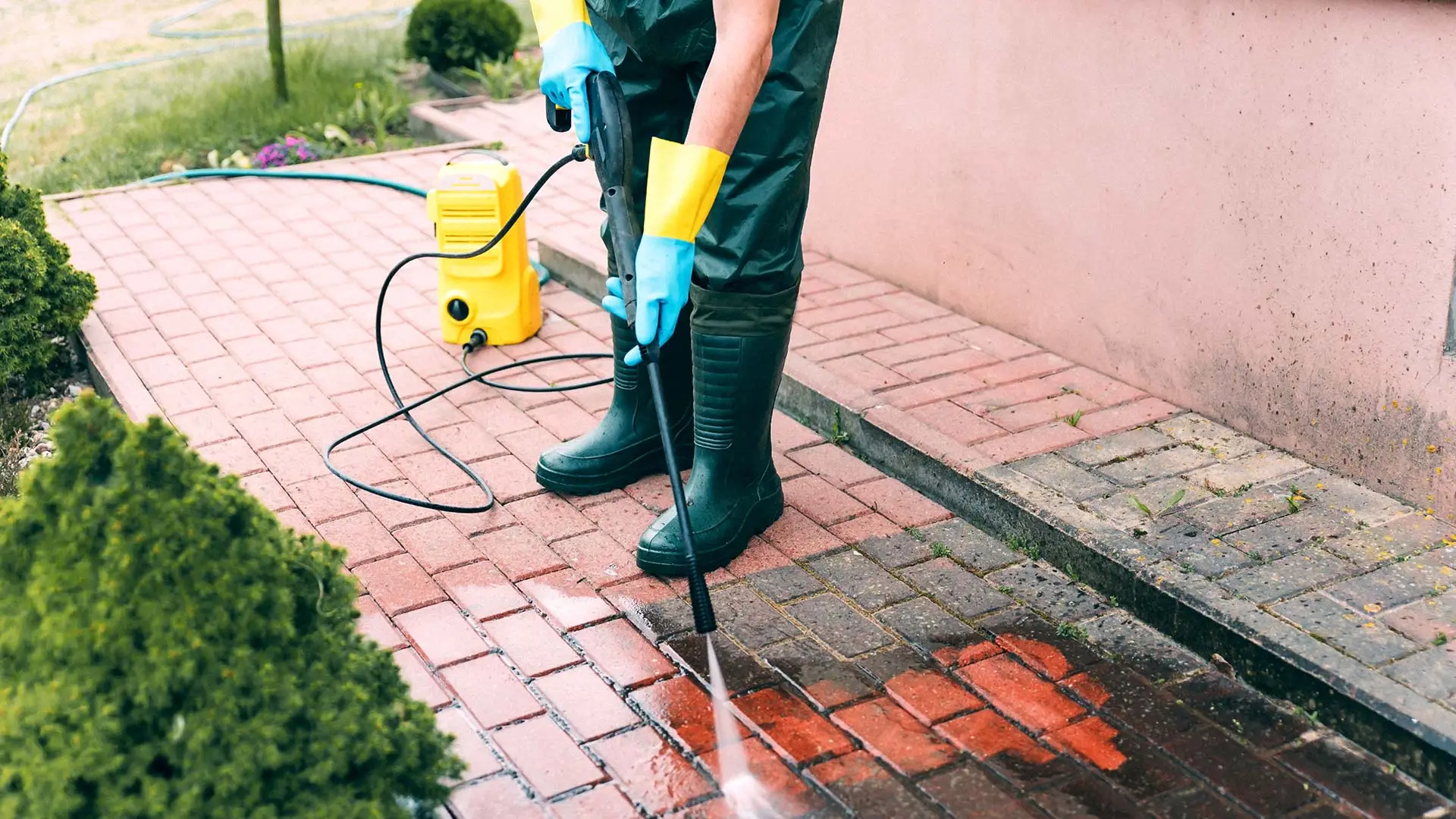 Professional cleaning dirty pavers with sprayer in New Braunfels, TX.