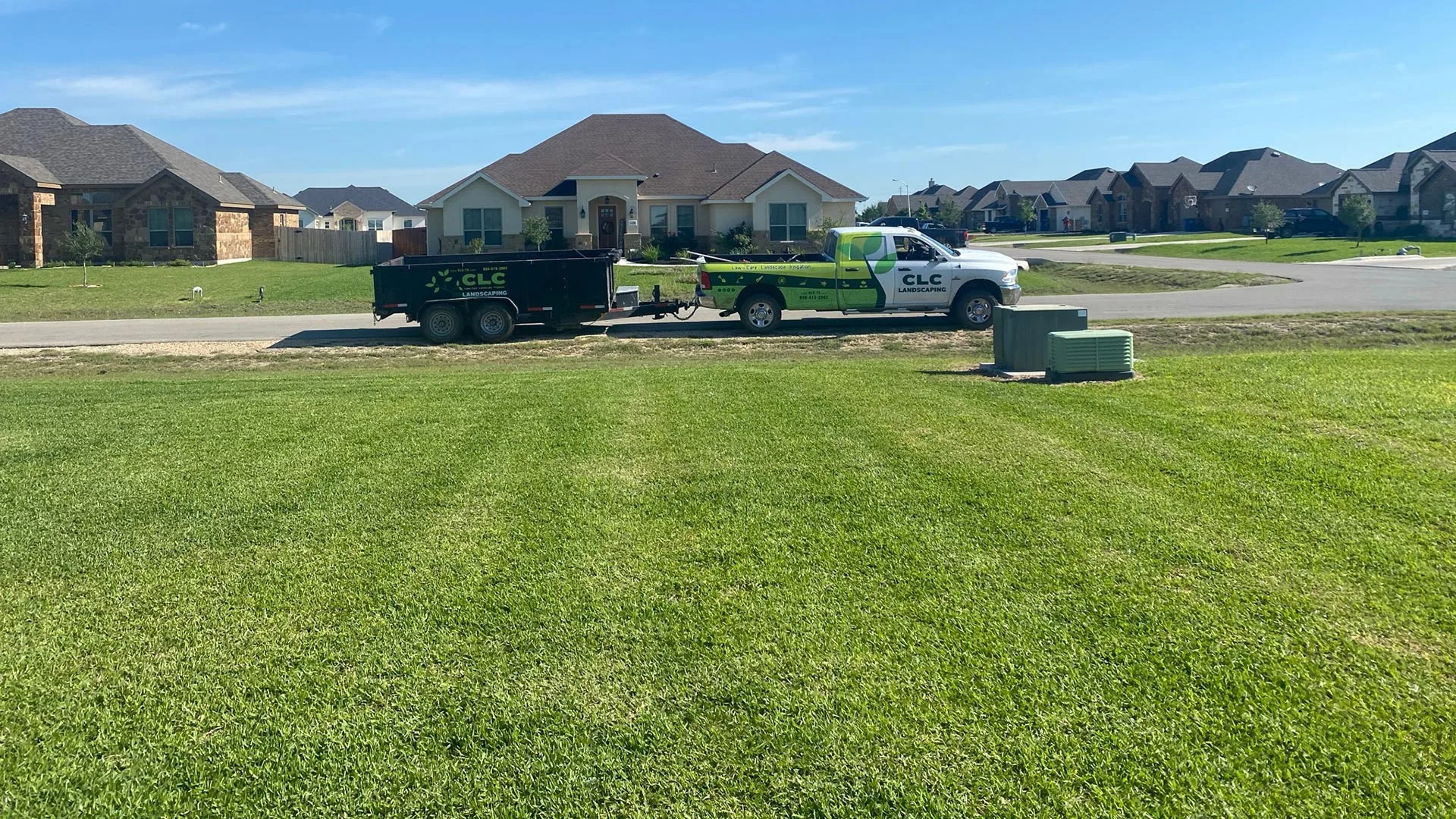 A large heathy field of grass in front of our company truck in New Braunfels, TX.
