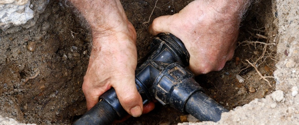 Professional repairing broken pipe of irrigation system in Kyle, TX.