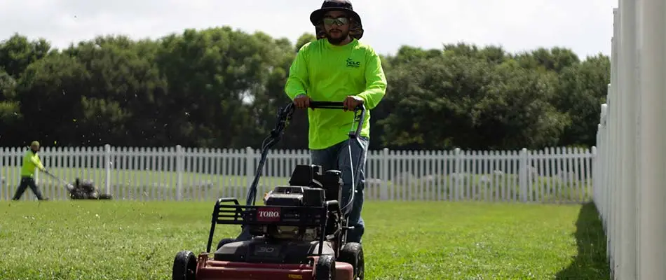 CLC Landscaping lawn care workers mowing a back yard near San Marcos, TX.