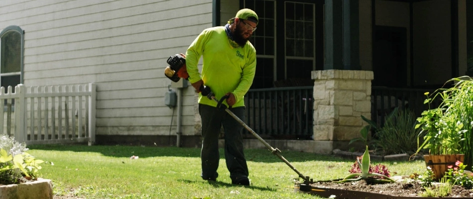 CLC professional string trimming a lawn in New Braunfels, TX.