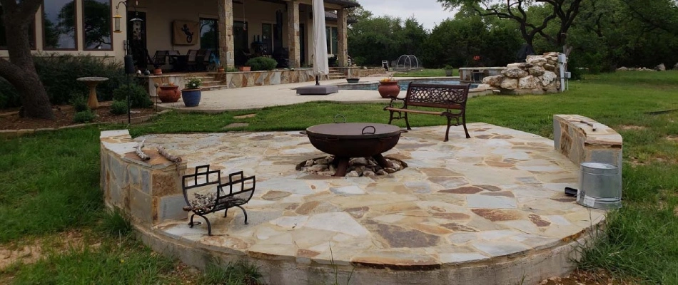 Fire pit installed over stone patio in Buda, TX.