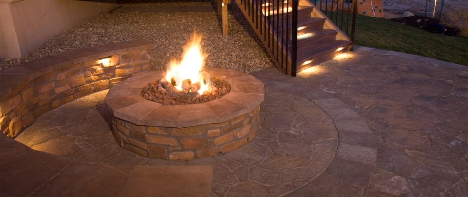Wood burning in a firepit installed by a seating wall in New Braunfels, TX.