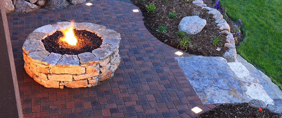 A custom built fire pit installed on a patio behind a home in New Braunfels, TX.