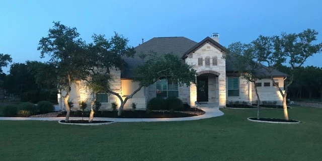 Landscape lighting installed around a home in New Braunfels, TX.