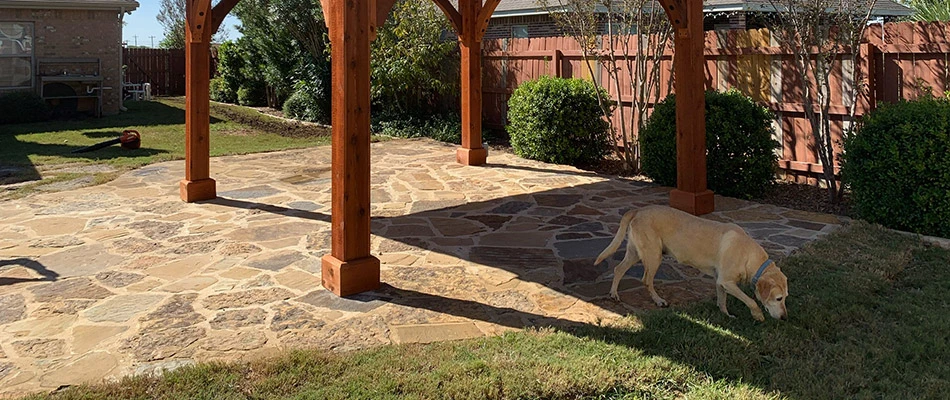 A flagstone patio built underneath a pergola on a property in Buda, TX.