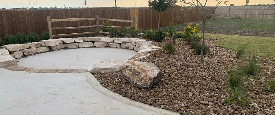 A paved patio with surrounding landscape beds in New Braunfels, TX. 