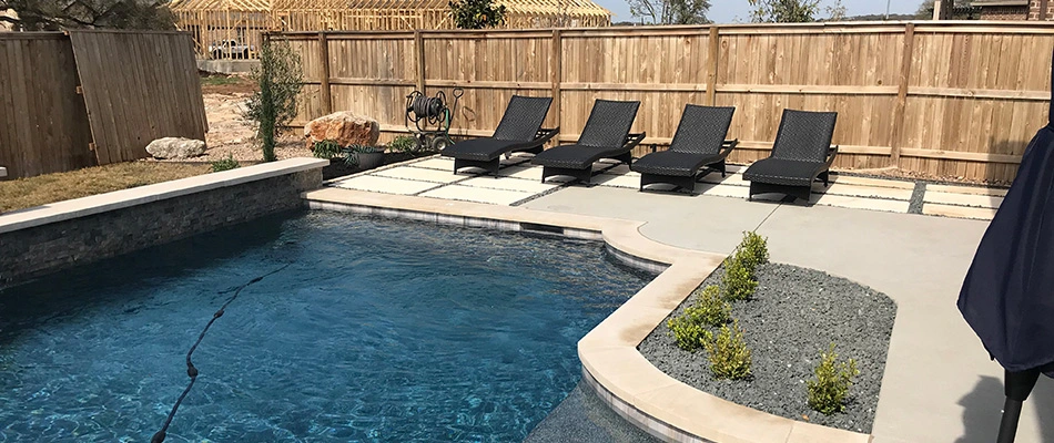 Pool deck hardscape installed with pavers in Comal County, TX.