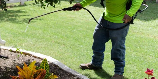 CLC Landscaping worker applying landscape bed weed control in Buda, TX.