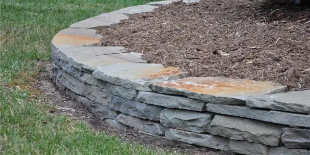 Custom retaining wall around a mulch bed near Buda, TX.