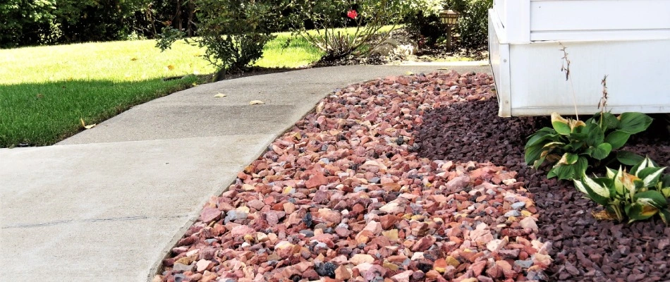 Rock and mulch ground covering in landscape bed installed in New Braunfels, TX.