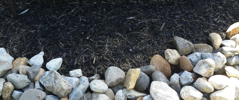 Rock and mulch ground covering retaining soil moisture in San Marcos, TX.