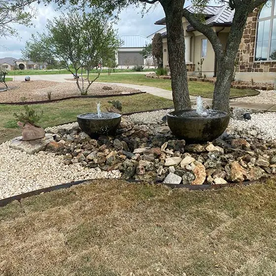 Custom landscaping with water bowl features in New Braunfels, TX.